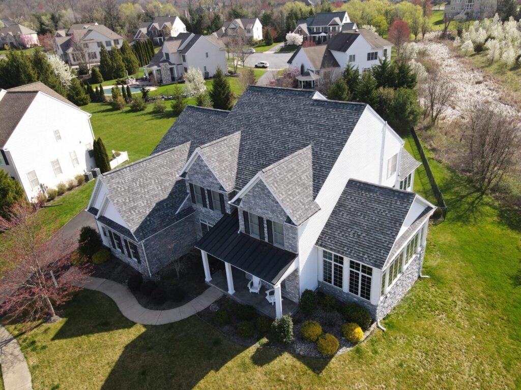 Elegant home with a multi-pitched roof featuring gray shingles.